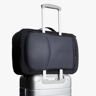 Black and gray bag on a silver suitcase with a white background