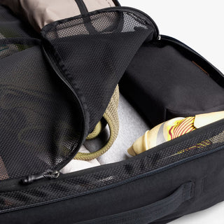 Black backpack with open compartment with clothing inside