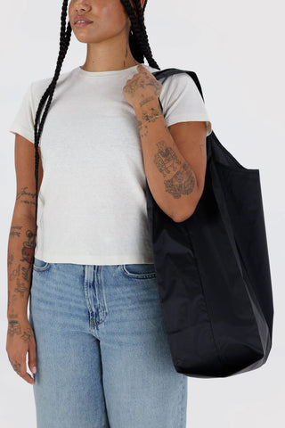 Large BAGGU black tote bag on model, slouchy shape with long rope handles