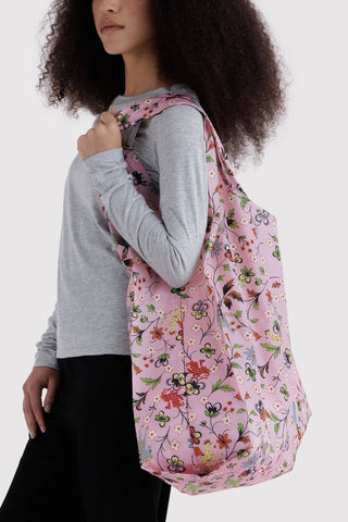 Large BAGGU tote bag in pink floral print, held over shoulder by model