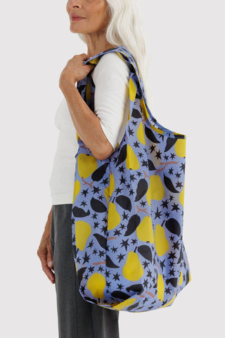 Big BAGGU tote bag held over shoulder, navy with yellow pear star print