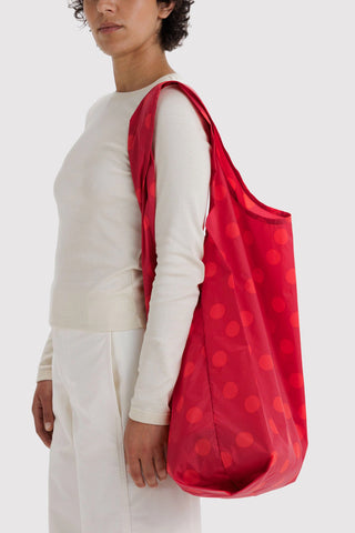 Red polka-dot tote bag carried on shoulder with gathered bottom