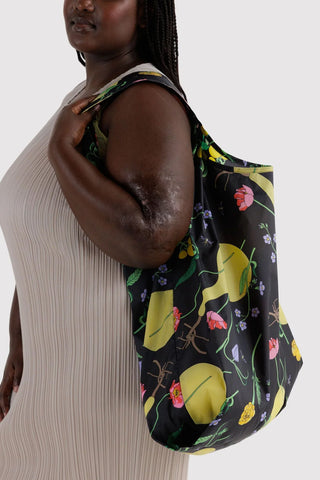 Big BAGGU tote bag worn by model, black with green gourd floral print
