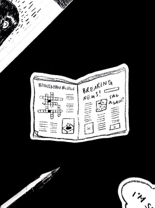 Sticker illustration of a newspaper with a crossword puzzle and text on a black background