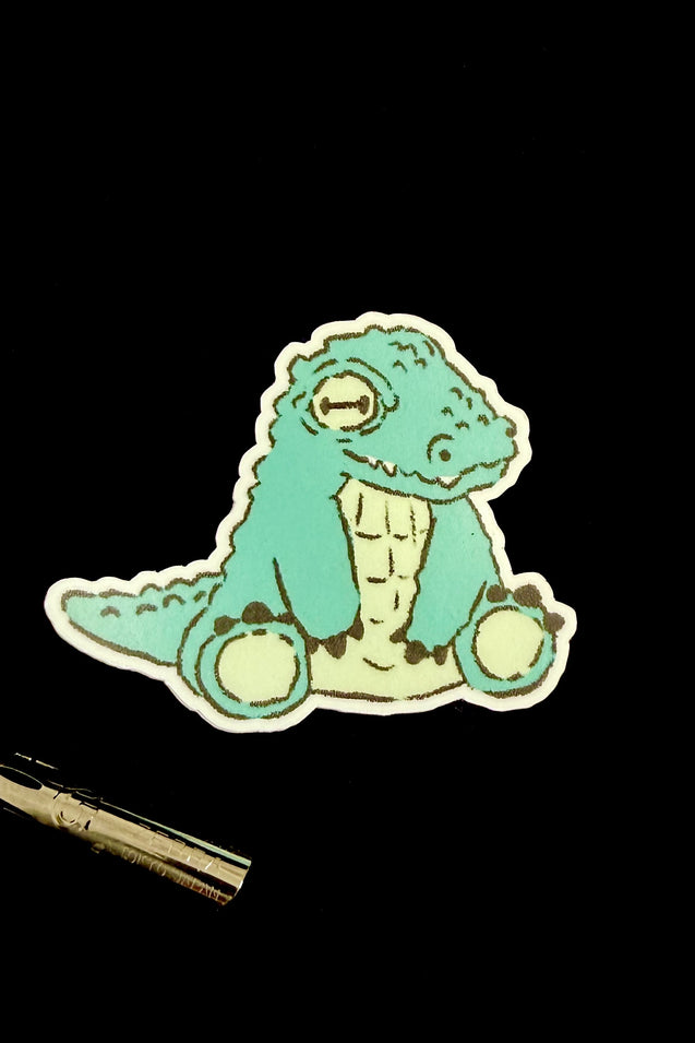 Mint green cartoon crocodile sticker with white outline
