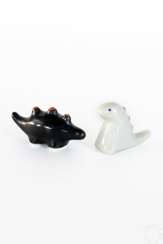 Ceramic dinosaur chopstick rest set: black stegosaurus and white tyrannosaurus
