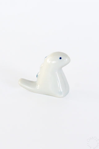 White ceramic tyrannosaurus chopstick rest, seated side profile
