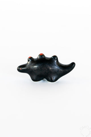 Black ceramic stegosaurus chopstick rest, front view