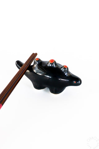 Black ceramic stegosaurus chopstick rest with wooden chopsticks