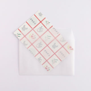 Patterned paper with cartoon chinchillas sliding into envelope