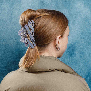 Blue and amber marble claw clip securing blonde low ponytail