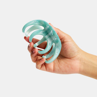 Large octopus claw hair clip held in hand, light blue translucent tentacle design.