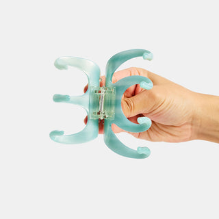 Large octopus claw hair clip close-up in hand, light blue translucent teeth detail.