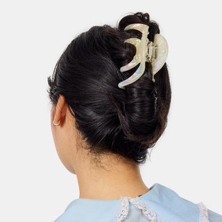 Large iridescent octopus claw hair clip on dark hair