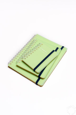 Green spiral notebook with black elastic strap and pen holder