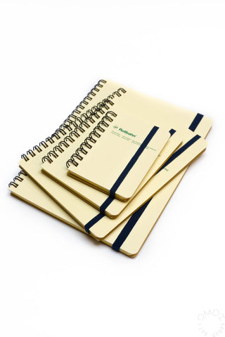 Cream spiral notebook with dark blue wrap and gold-edged cover