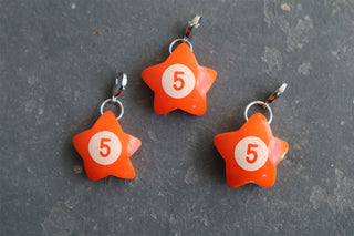 Orange wonky star charm with white '5' and metal jump ring, three charms shown