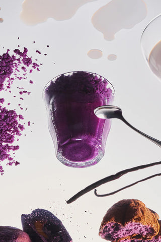 Purple ube candle wax with scoop, scattered wax pieces, and a partial wick
