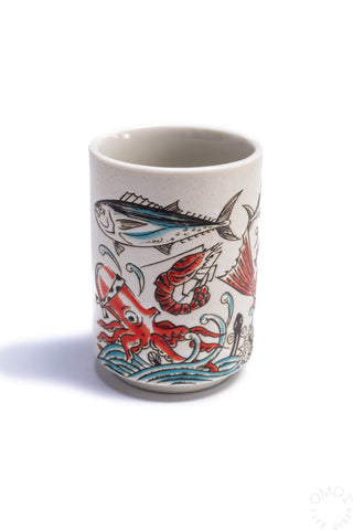 Fish teacup, cream ceramic with red and blue fish pattern on side