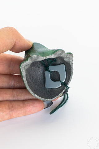 Hand holding a bottom of wind chime showing bell