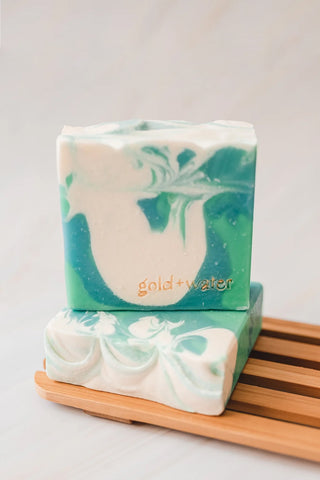 GOLD+WATER CO. handcrafted soap bars, teal and white leaf marbled, on wooden tray