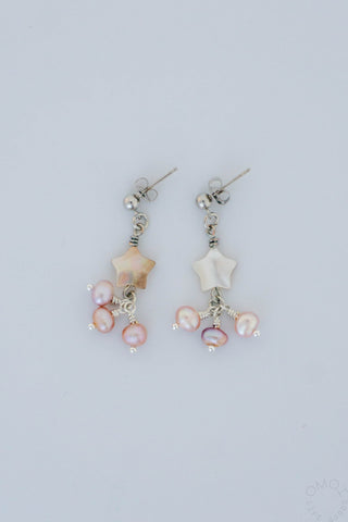 Pair of star pearl earrings on a white background