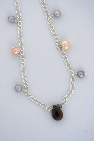 Close up of main pendant of tear necklace on a white background