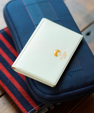 White wallet with the beams japan logo on a blue textured surface