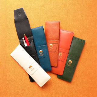 Set of six colorful pen cases with the beams japan logo on an orange fabric background