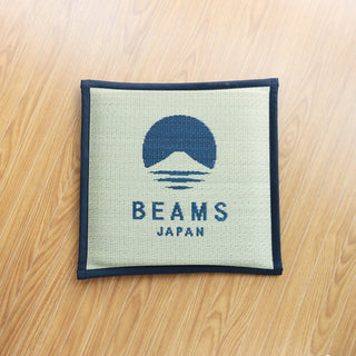 Square cushion with BEAMS Japan logo on a wooden surface