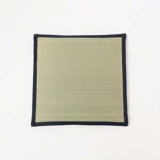 Square woven mat with navy border on a white background
