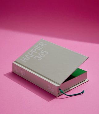 Book titled 'Happier 365' on a pink background