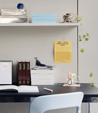 Modern office desk with books, a calendar, and decorative items.