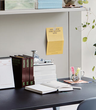 Desk with books, a calendar, and stationery items in a home office setting.