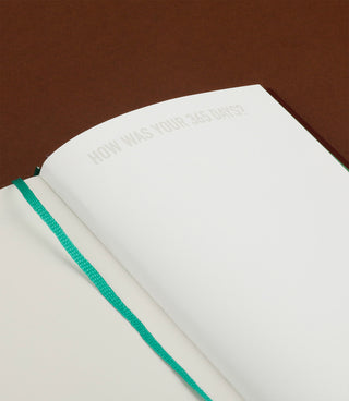 Open notebook with a question prompt on a brown background
