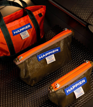 bags with 'Happier' branding on a textured surface
