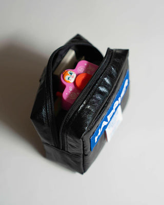 Black pouch with colorful items on a white background
