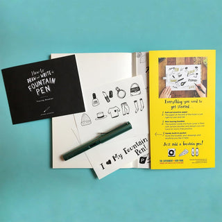Fountain pen set with instruction booklets on a teal background