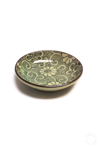 Ceramic plate with green floral pattern on a white background
