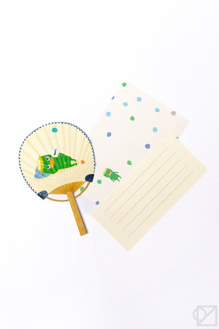 Handheld fan with cartoon design and matching paper on a white background