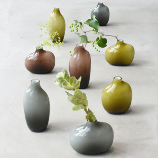 Set of small ceramic vases in various colors on a light background