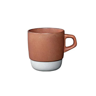 Ceramic mug with orange top and grey bottom on a white background