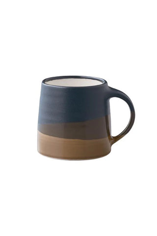 A ceramic coffee mug with a three-tone horizontal color-blocked design in navy blue, dark brown, and warm tan, shown against a plain white background.