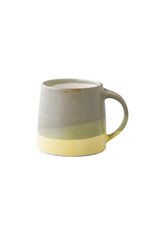 Two-tone ceramic mug with a gradient with beige, green, yellow on a white background