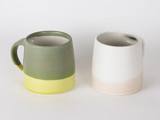 Two ceramic mugs with gradient colors on a white background