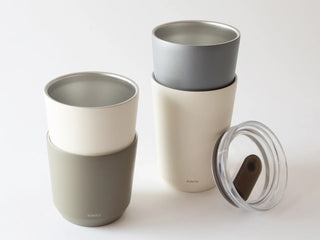 Insulated travel mugs with different color schemes on a white background