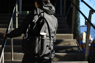 Person with a backpack walking up with a thermos in their backpack pocket