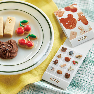 Kitta cookie sticker packaging with cookies on a plate and on a table.