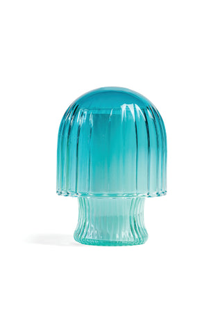 Blue glass candle with lid in the shape of a mushroom on a white background