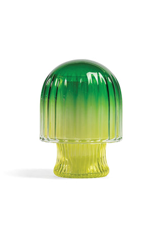 Green and yellow gradient glass candle in the shape of a mushroom on a white background